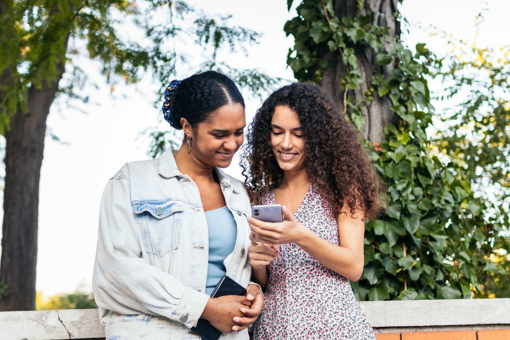 Lesbian couple walking down the street, holding hands.