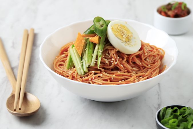 Korean noodle dish plates with boiled egg and fresh vegetables