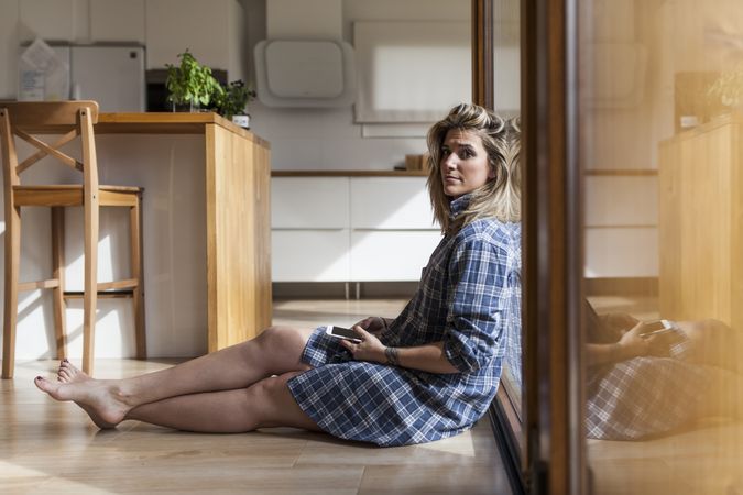 Woman at home leaning in a windows