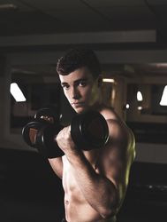 Powerful man exercising with dumbbells