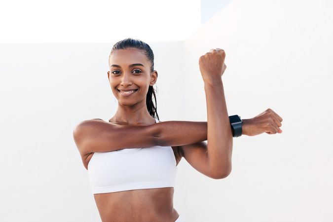 Smiling woman warming up her muscles before exercises