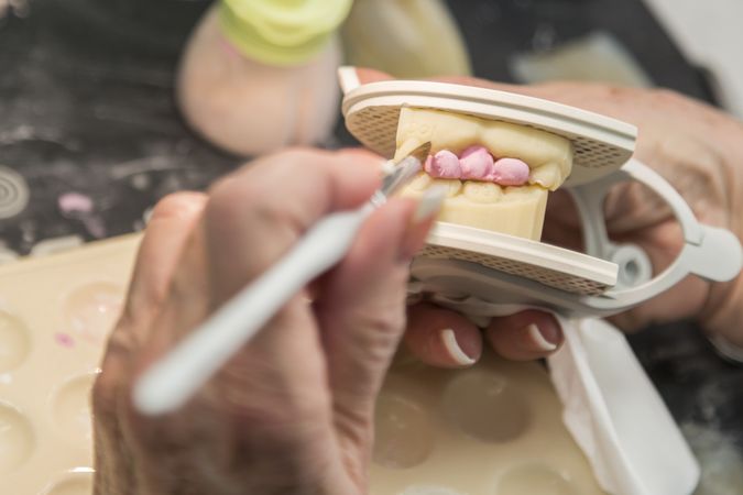 Dental Technician Applying Porcelain To 3D Printed Implant Mold