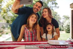 Smiling man taking a selfie with his family members using a mobile phone 5pNEAb