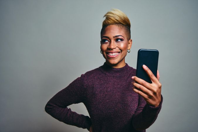 Black woman smiling and looking away from a text on a cell phone