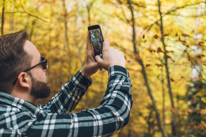 Casual tourist making photo on smartphone of nature