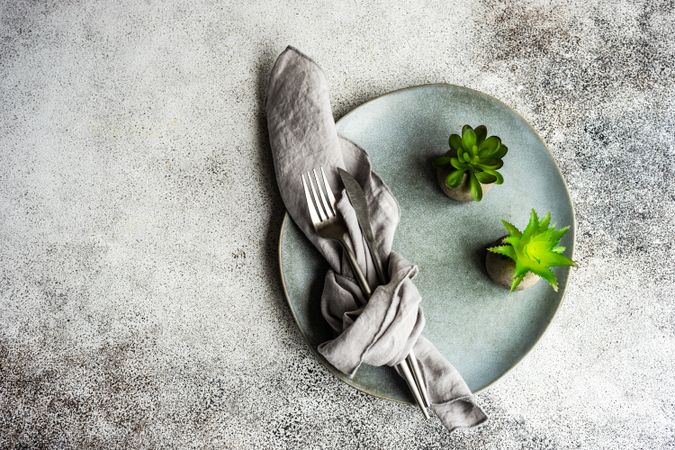 Light table setting with succulents on concrete background