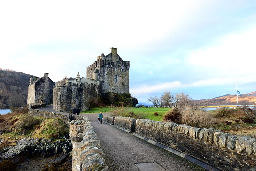 Person near Eilean Donan Castle in highland of Scotland