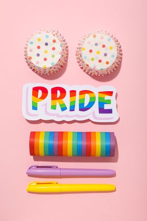 Pride parade concept, holiday symbols on pink background.