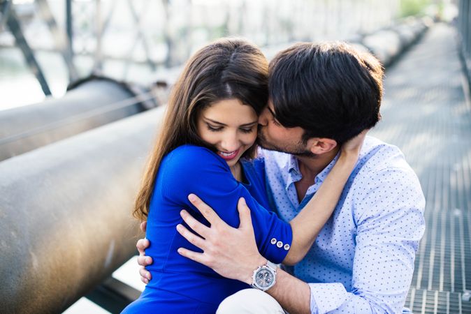 Amorous couple bonding on railway under bridge