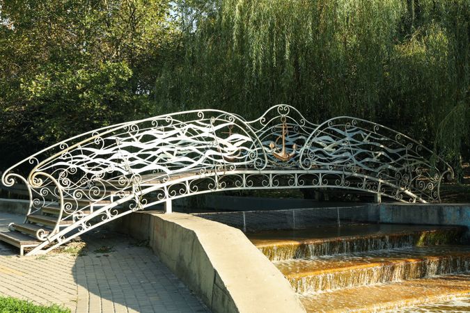 Little bridge in city park in bright sunny morning