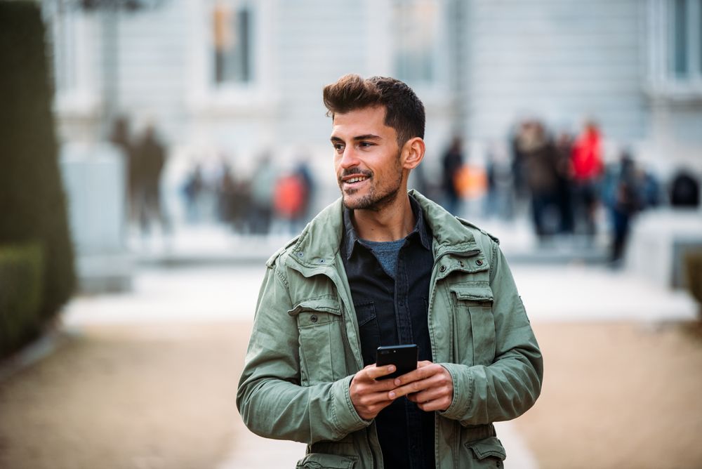 Young man on the mobile phone and walking