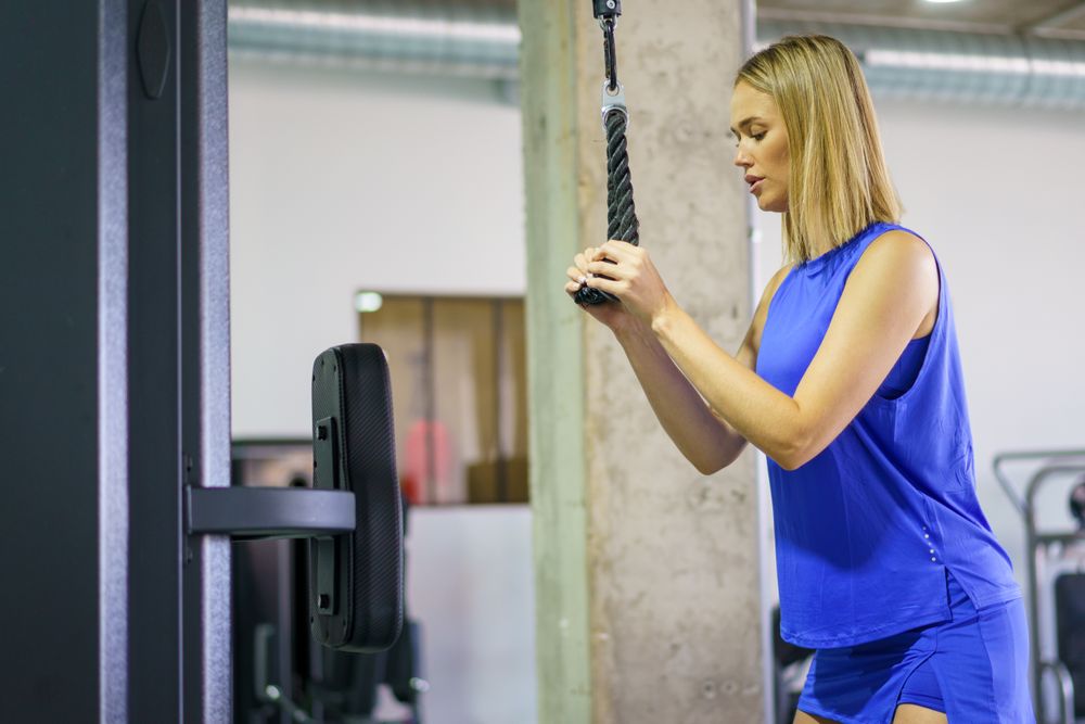 Woman doing arm exercise in weight room