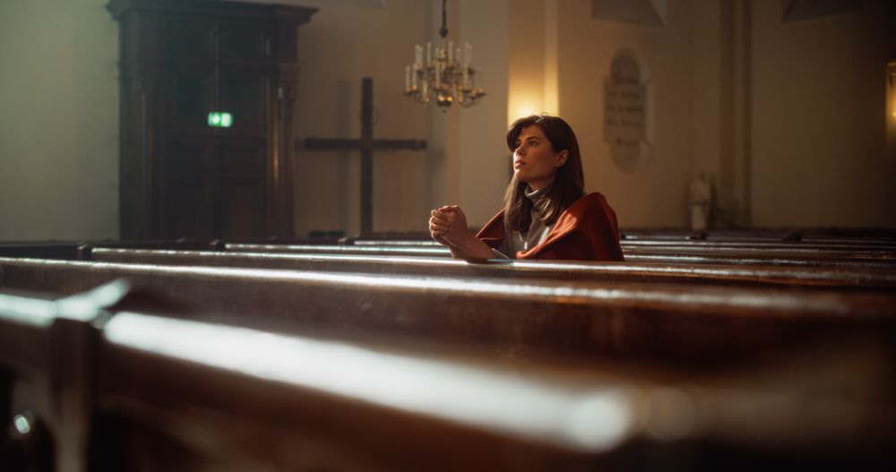 Portrait of a Young Woman Praying in the Majestical Old Church.