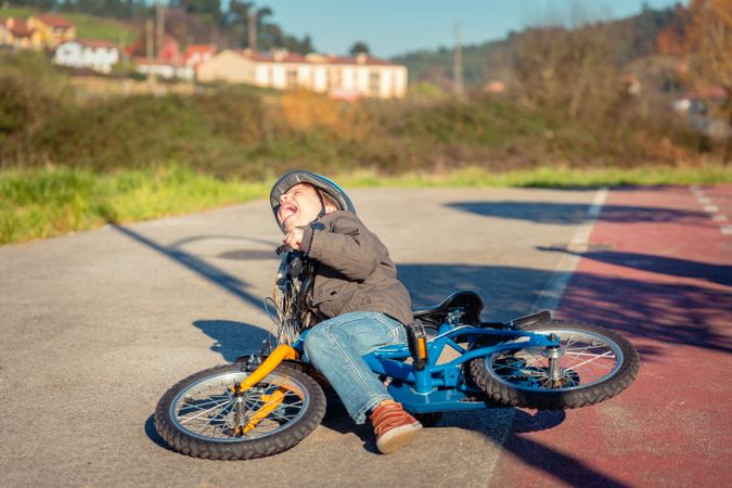 Boy on his side after falling off his bike
