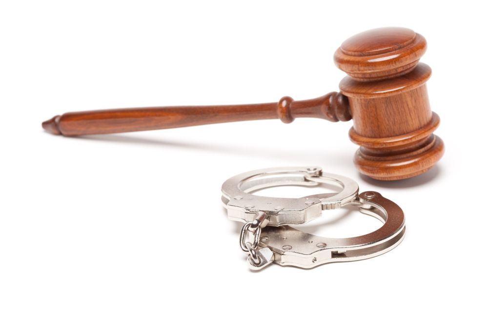 Gavel and Handcuffs on Plain Table