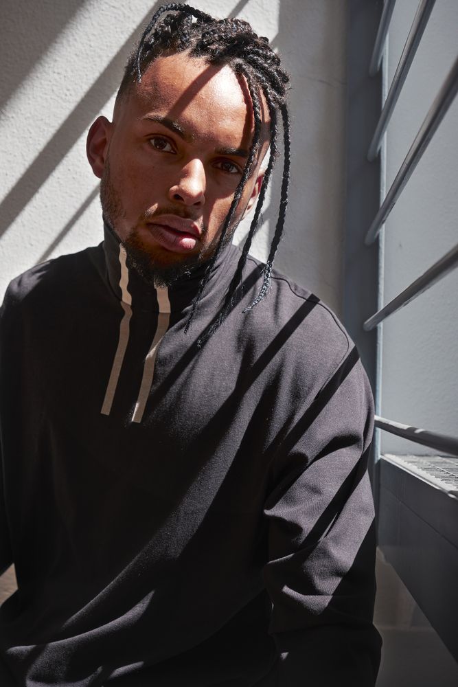 Stylish Black male sitting on railing