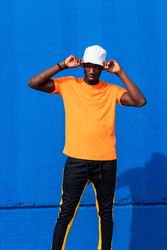 Black man in bright sporty outfit and cap