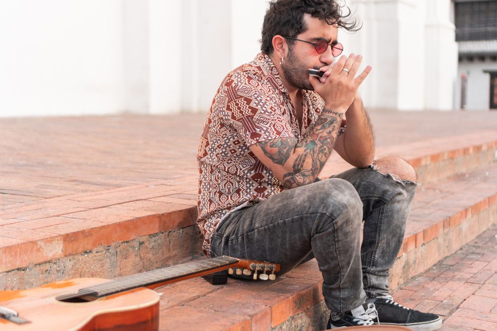 Young man playing music on a staircase in the street