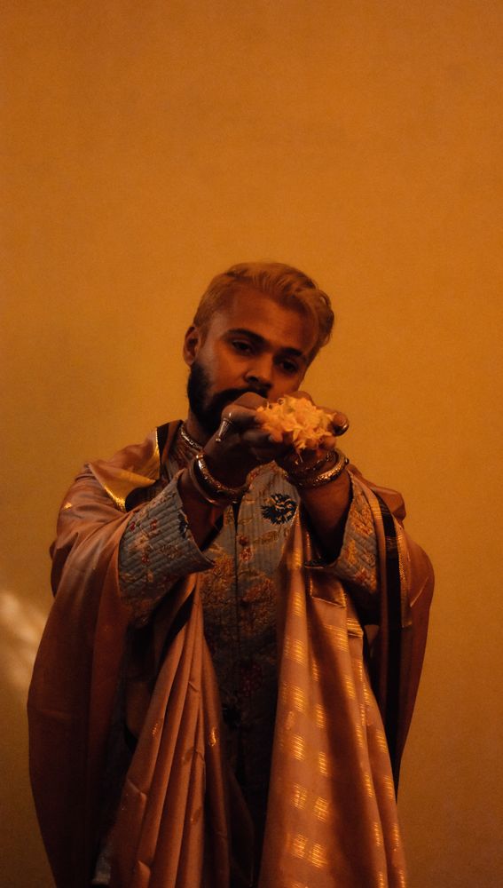 Indian man in a garment holding flowers