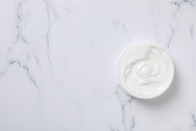 Jar with cream on light background, space for text