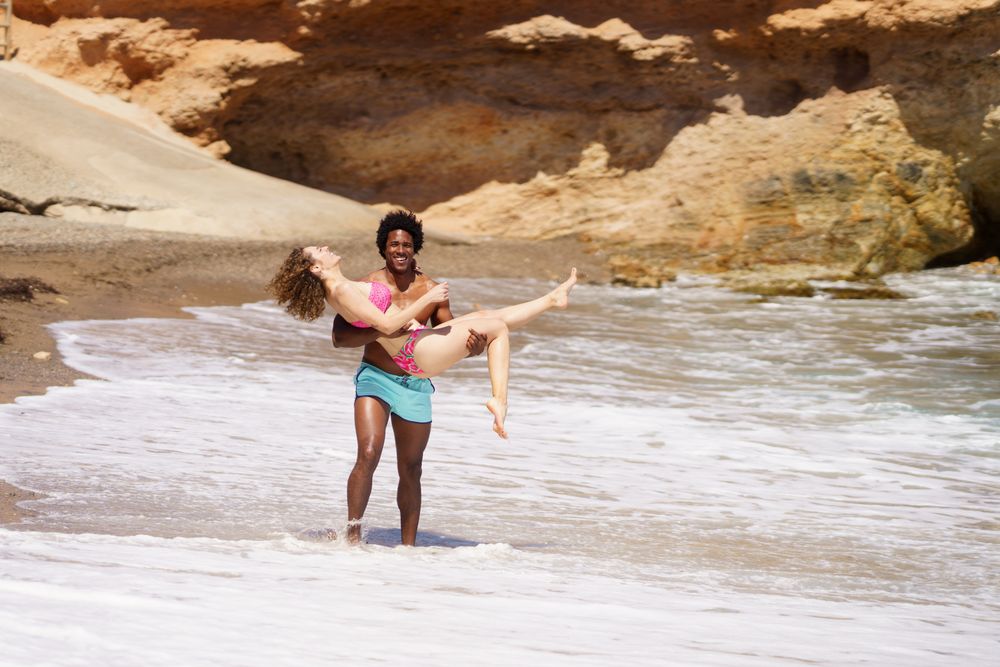 Happy diverse couple having fun on beach