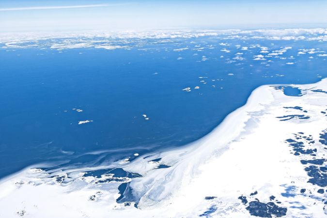 Blue sea near snowy shore