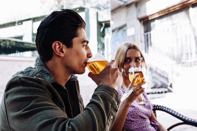 Happy young couple drinking beverages outdoors