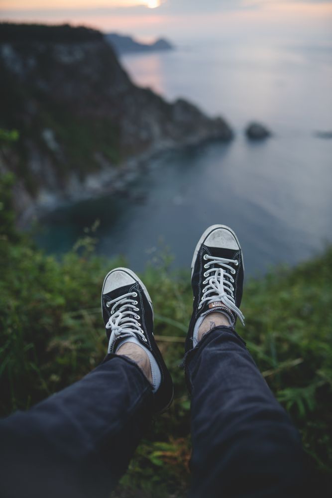 Person legs on seascape background during sunset