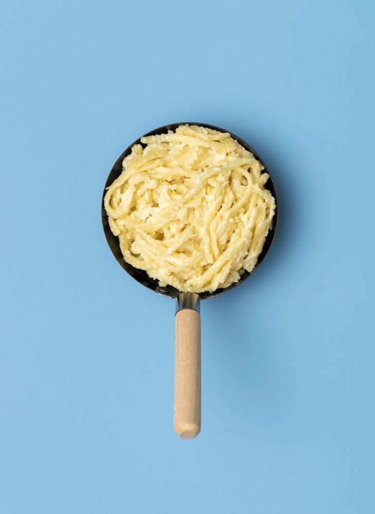 German pasta with cheese in a pan, above view on a blue table