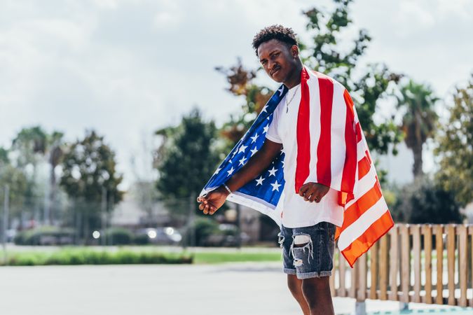 Black man wrapping American Flag outside