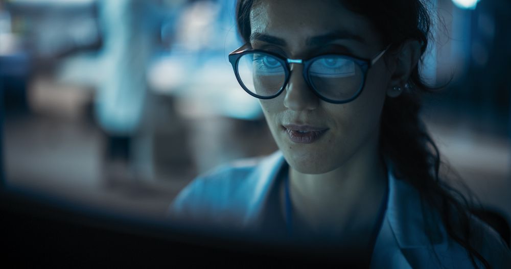 Portrait of Woman Working on Computer with the Screen Reflecting in Her Glasses.