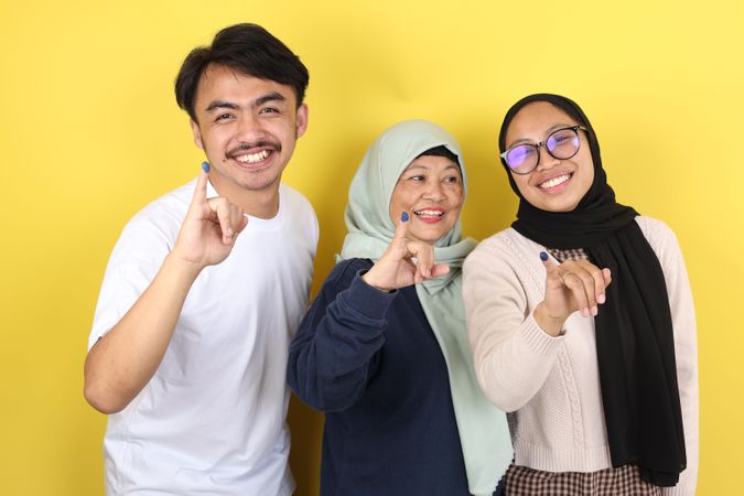 Three People Indonesain Family Showed Tinta Pemilu, Inked Finger after Voting for General ELection or Pilkada