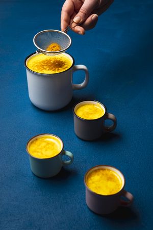 Turmeric latte in cup and spice powder