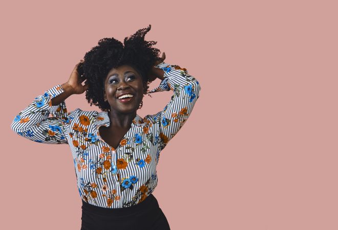 Portrait of Black woman with a joyful expression and both hands to her head