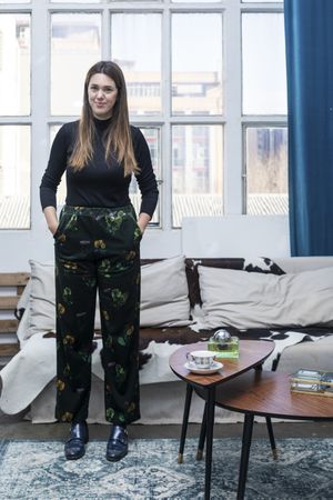 Long haired woman standing in front of window in living room