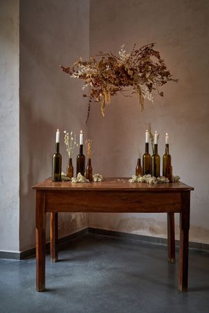 Decor of table with bottles on and flowers above
