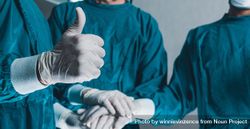 Wide shot of medical staff in scrubs with thumbs up 5rw3d4