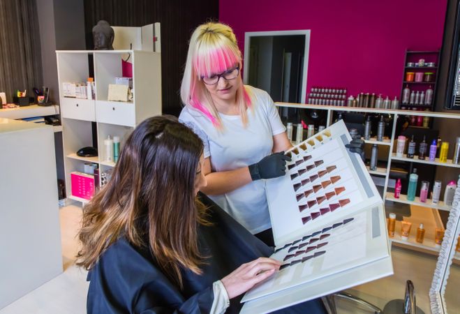 Hairdresser and client choosing hair color