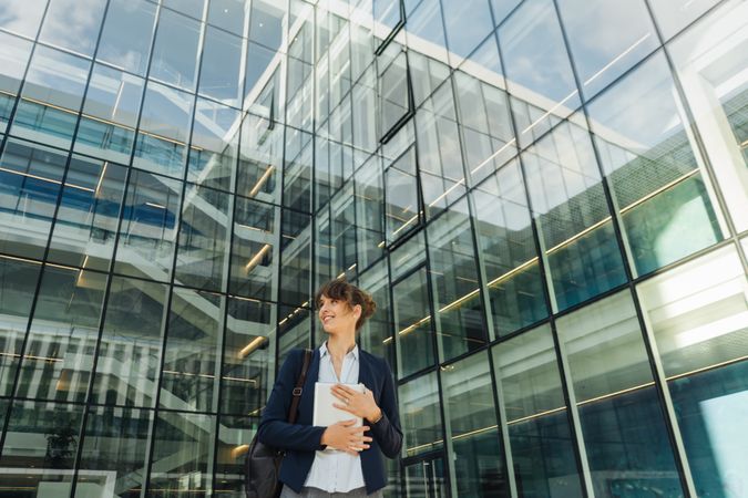 Positive businesswoman using tablet on street