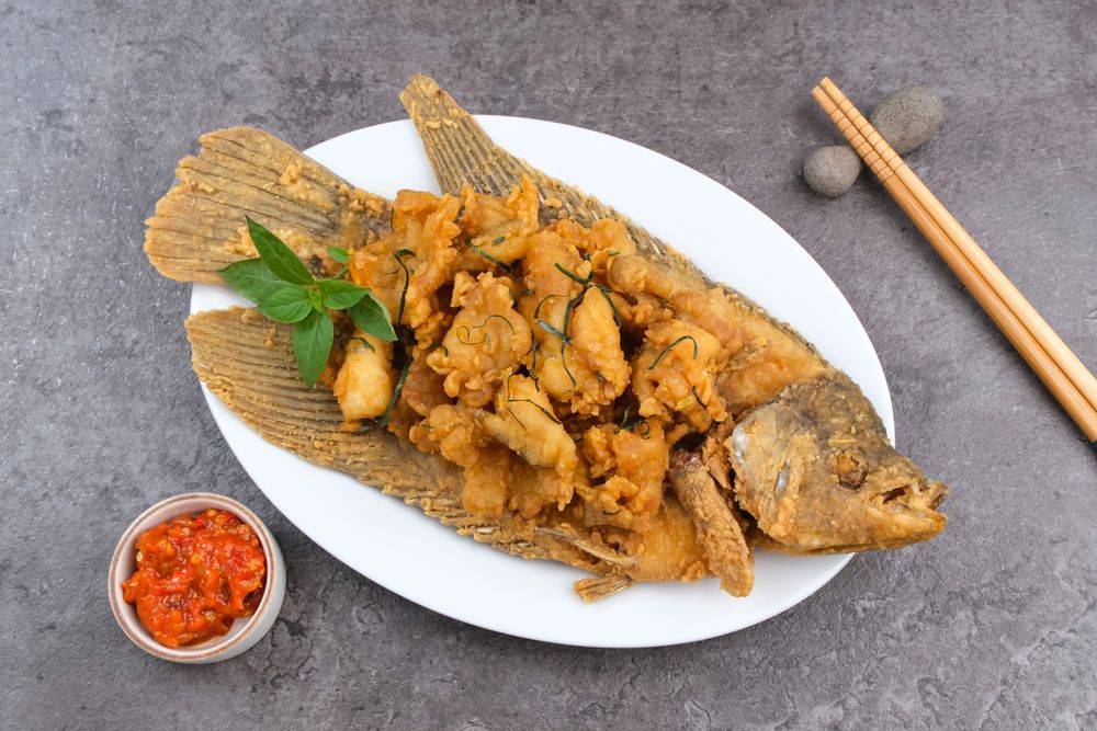 Gurame Saos Telur Asin. Crispy fried gourami fish covered with salted egg sauce. Indonesian food