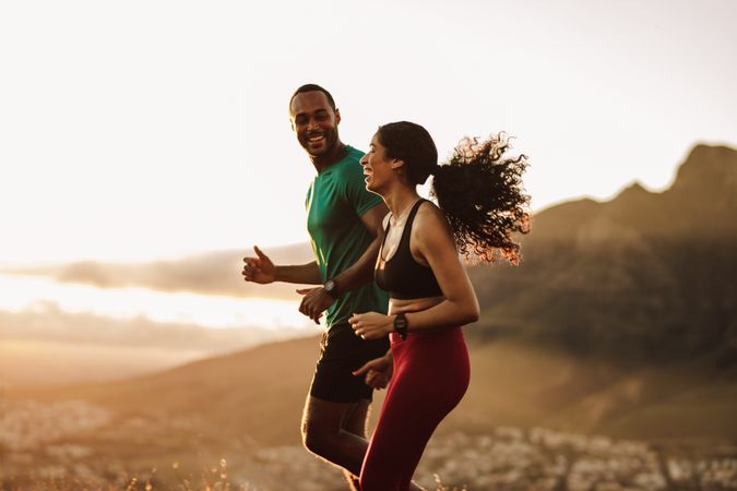Fitness couple enjoying their early morning run on a hill