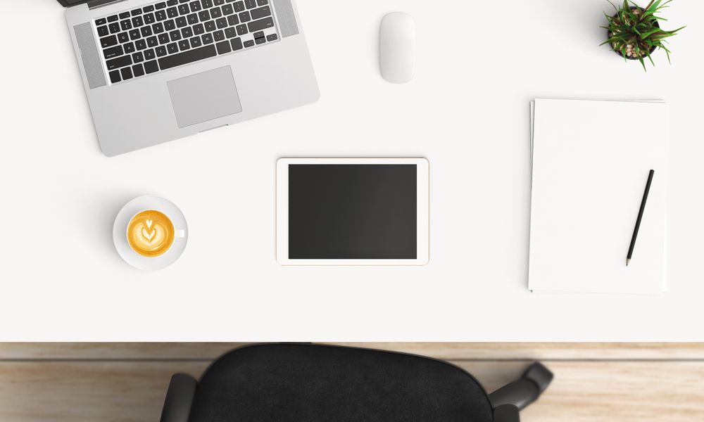 Modern workplace with coffee cup and smartphone or laptop copy space on office table background. Top view. Flat lay style