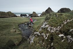 Woman walking along mountain river estuary