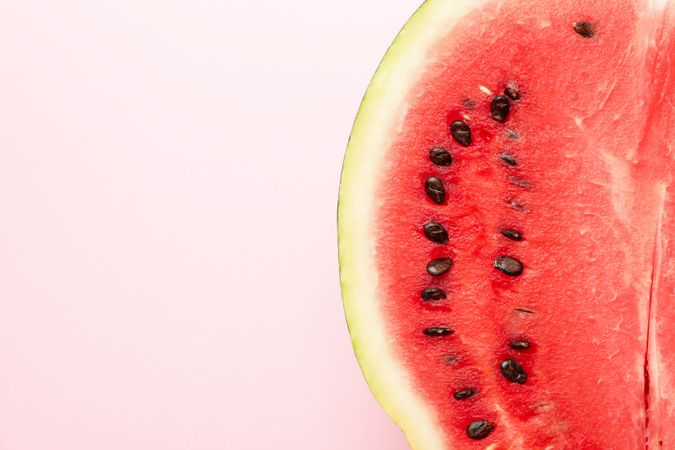 Half of fresh watermelon on pink background. Summer fruit