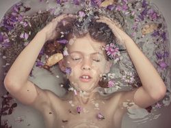 Boy underwater in bathtub with flowers