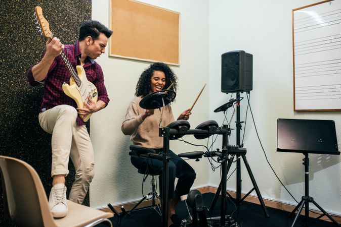 Man playing guitar and woman playing drums