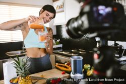 Food blogger recording a vlog on camera on fresh and healthy smoothie 4OYxL0