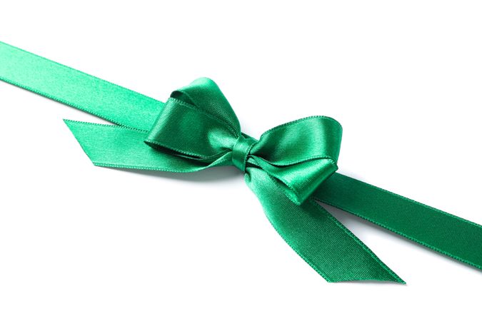 Green ribbon with bow isolated on plain background. Gift concept