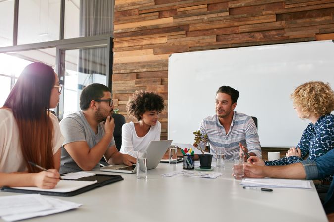 Office workers discussing new business plan together in conference room