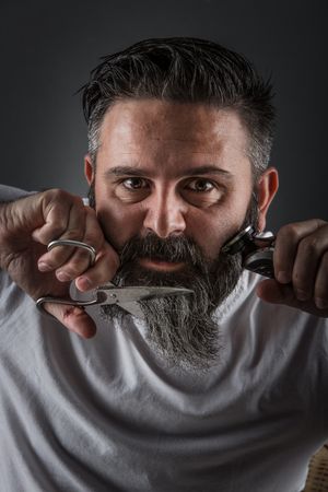 Expressive barber cutting beard